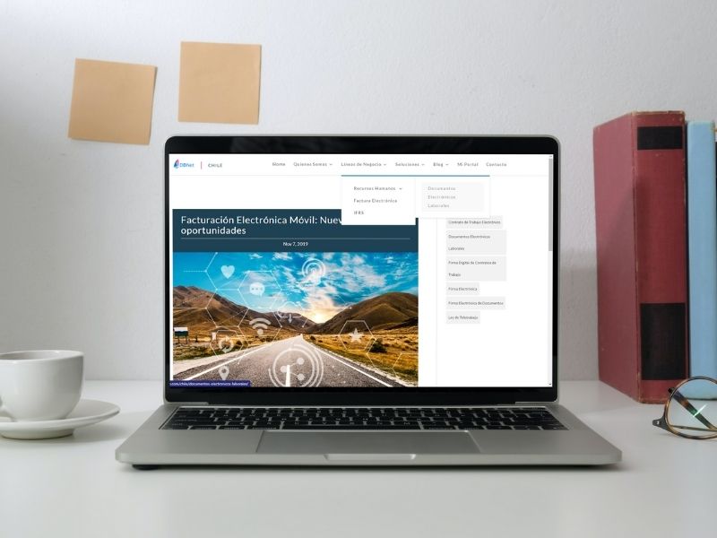 Laptop on a desk showing a website on its screen.