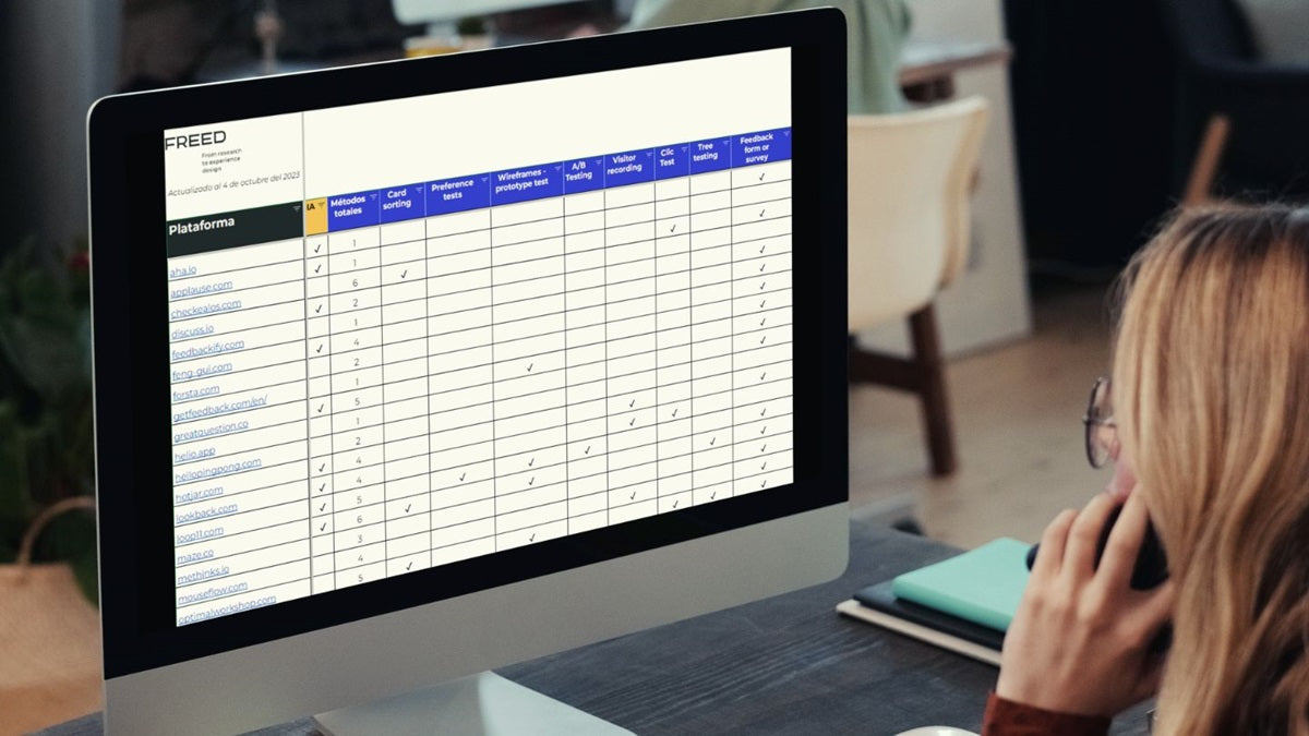 Woman in front of a computer screen showing a spreadsheet with cells full of data.