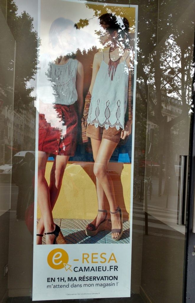 Shop window showing a large poster with a photograph of two women posing