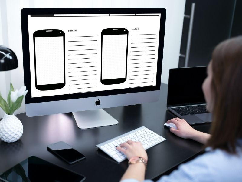 Woman working on her computer. Prototyping pads are visible on the screen.