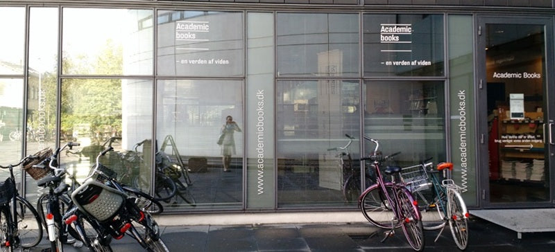 Facade of Academic Books stores, showing their shop windows and several parked bicycles