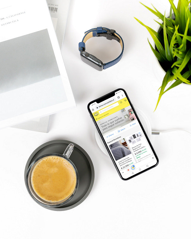 Desk with a cactus, a coffee cup, and a smartphone showing an e-commerce marketplace website.