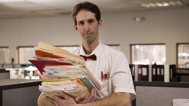 Man holding a stack of documents.