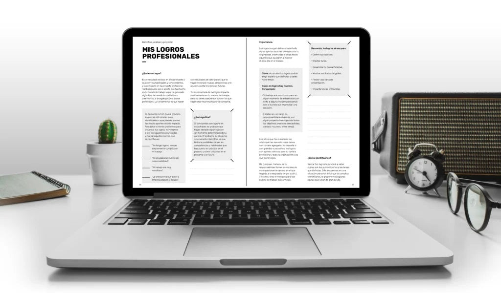 The digital version of the planner viewed on a laptop screen, on a desk where glasses, a speaker, a notebook, a watch, and a small cactus are visible.