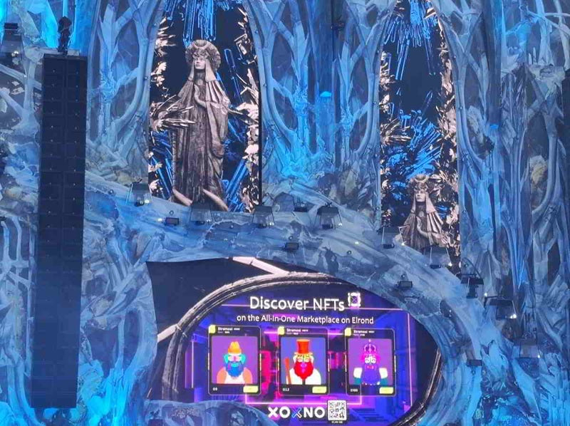 Close-up of part of the stage showing a screen displaying NFTs